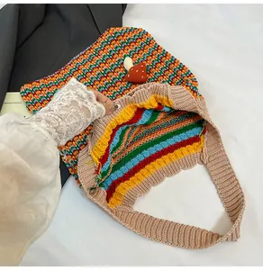 Close-up of knit tote bag featuring mushroom charm and colorful rainbow stripe lining
