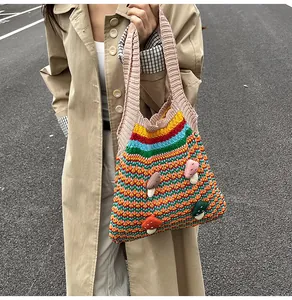 Detail of colorful striped knitted tote bag with 3D mushroom patches and pink handles