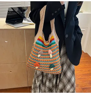 Close-up of knit tote bag with colorful rainbow stripes and 3D mushroom patches
