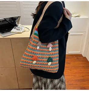 Detailed knit tote bag featuring colorful stripes and cute 3D mushroom decorations