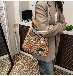 Detail of hand-knitted tote bag featuring colorful stripes and cute 3D mushroom accents