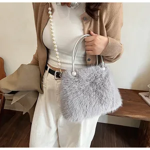Detail of grey faux fur handbag with elegant large pearl strap and silver metal handles