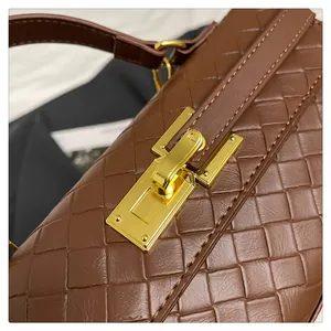 Macro detail of brown woven leather handbag with gold rectangular metallic closure