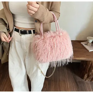 Detail of pink faux fur handbag with beaded pearl chain and gold metal strap