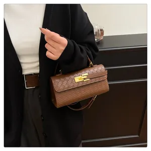 Close-up of brown quilted faux leather handbag with elegant gold metal twist lock buckle