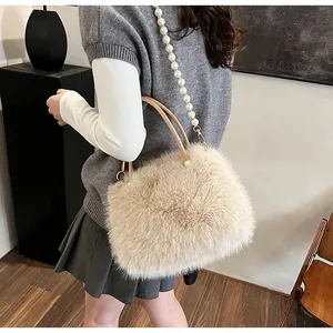 Detailed texture of fluffy apricot faux fur handbag with elegant pearl bead shoulder strap