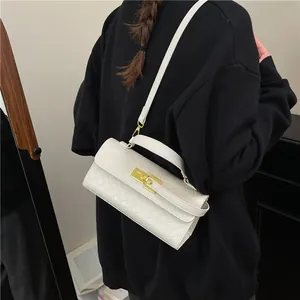 White woven crossbody bag with gold hardware worn by a model over a black hoodie