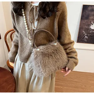 Detail view of light brown faux fur handbag with elegant large pearl handle decoration