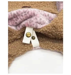Close-up of metal snap button with pink leopard faux fur and brown sherpa fabric detail