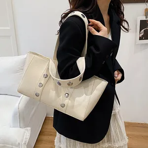 Chic beige tote bag with silver studs and minimalist design for stylish daily use