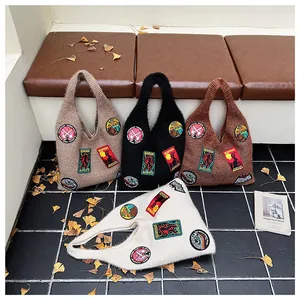 Detail of knit tote bags in four colors featuring retro embroidered creature patches