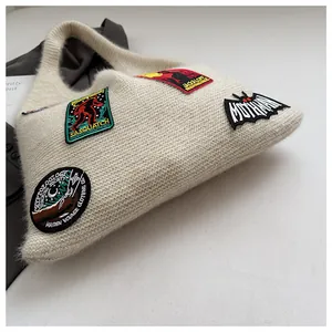 Close-up of knit tote bag with Sasquatch and Mothman embroidered monster patches