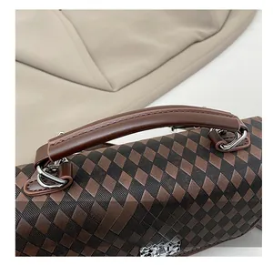 Vue macro du sac à main en cuir à carreaux avec détail de boucle tête de serpent argent