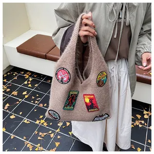Macro detail of brown plush knit tote bag featuring colorful mythical creature patches