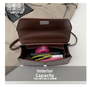 Détail de l'intérieur d'un sac en cuir marron montrant sa grande capacité et son fermoir