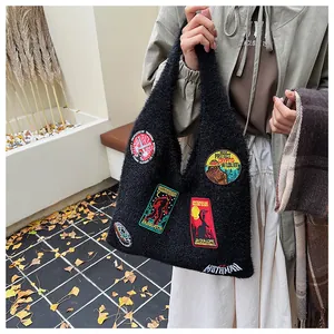 Close-up of black fuzzy tote bag with colorful mythical creature embroidery patches