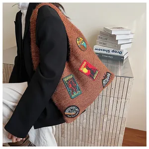 Close-up of brown knit tote bag featuring retro embroidered mythical creature patches