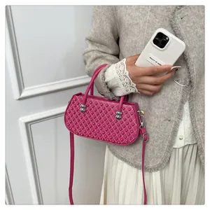 Detalle del bolso bandolera rosa con diseño acolchado de rombos y remaches decorativos