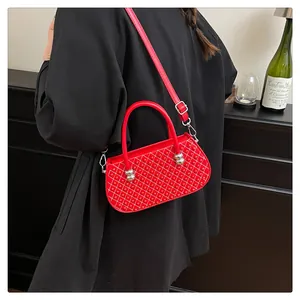 Detalle del bolso rojo acolchado con tachuelas y cierre de bola de metal plateado