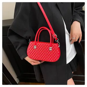 Detalle de mini bolso rojo acolchado con tachuelas doradas y herrajes metálicos plata