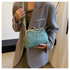 Detail van groene handtas met bloemenreliëf en luxe met strass ingelegde sluiting