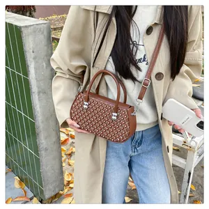 Detalle de bolso bandolera marrón con cuentas de rejilla y correa ajustable de mujer