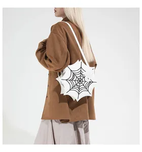Macro detail of white gothic spider web shoulder bag with black embroidery on a model