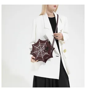 Detailed view of gothic spider web crossbody bag in dark red leather with spider detail