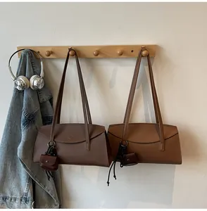 Close-up of brown faux leather tote bags with matching mini pouches and shoulder straps