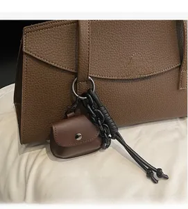 Detailed view of deep brown litchi pattern leather mini pouch with metal snap button