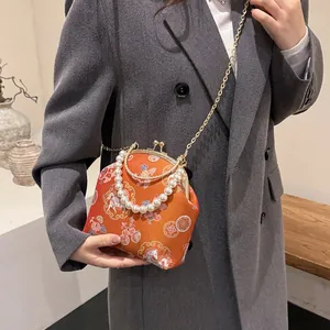 New Chinese shell handbag with orange embroidery, pearl handle, and gold chain strap