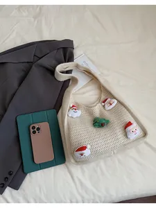 Detailed macro view of beige knit bag with festive 3D Santa and Christmas tree patches