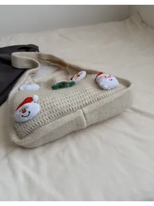 Detail view of cream knit shoulder bag with 3D Santa and Christmas tree decorations