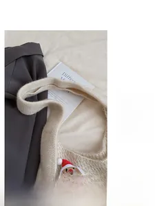 Close-up of a cozy knit shoulder bag featuring a cute Santa Claus pattern for Christmas