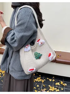 Detailed knit texture of a cream shoulder bag with 3D Santa and Christmas tree decor