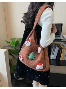 Close-up of brown knit shoulder bag with Santa pendants and Merry Christmas embroidery