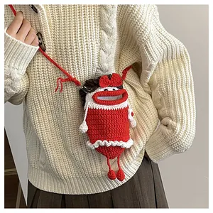 Detailed close-up of knitted crossbody bag featuring unique sausage lips and red bow decor