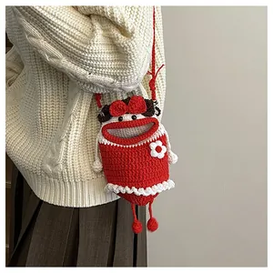 Detail of red handmade crochet crossbody bag featuring a cute character with a wavy skirt
