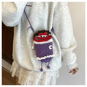 Detail of purple handmade crochet monster bag with red lips and floral accents