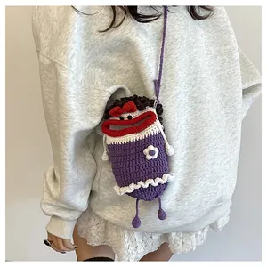 Close-up of a handmade purple knit phone bag with funny face design and flower detail