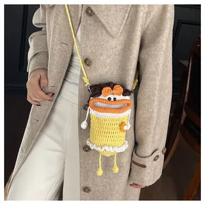 Detail showing hand-knit yellow cartoon bucket bag with cute 3D lips on a model coat