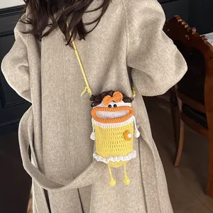 Cute knitted bucket phone bag in yellow featuring cartoon face and orange bow detail