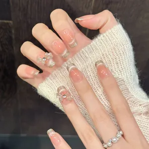 Handgefertigte rosa Katzenauge-Kunstnägel mit Goldglitzer-Verlauf und Strass-Schleifen