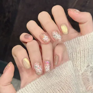 Handgemachte Kunstnägel mit weißen Blumenmustern und goldenen Schimmer-Details
