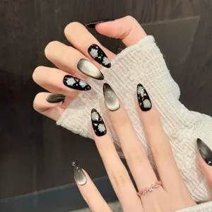 Elegant black cat eye press-on nails with golden foil and white floral hand-painted designs