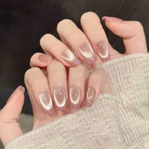 Detail of pink cat-eye press-on nails with sparkling glitter French tips on square shape