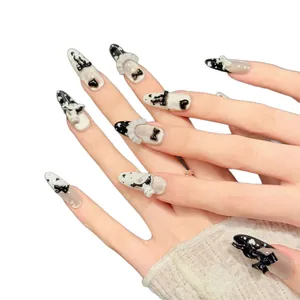 Long almond-shaped press-on nails featuring black and white cat motifs and 3D bows