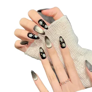 Handcrafted black and gold cat-eye press-on nails with floral patterns and gold foil detail