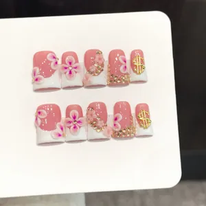 Pink and white 3D floral press-on nails with gold studs and dollar sign charms