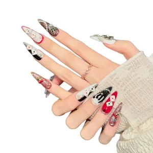 Gothic stiletto press-on nails with poker motifs, pink glitter, and 3D skull charms